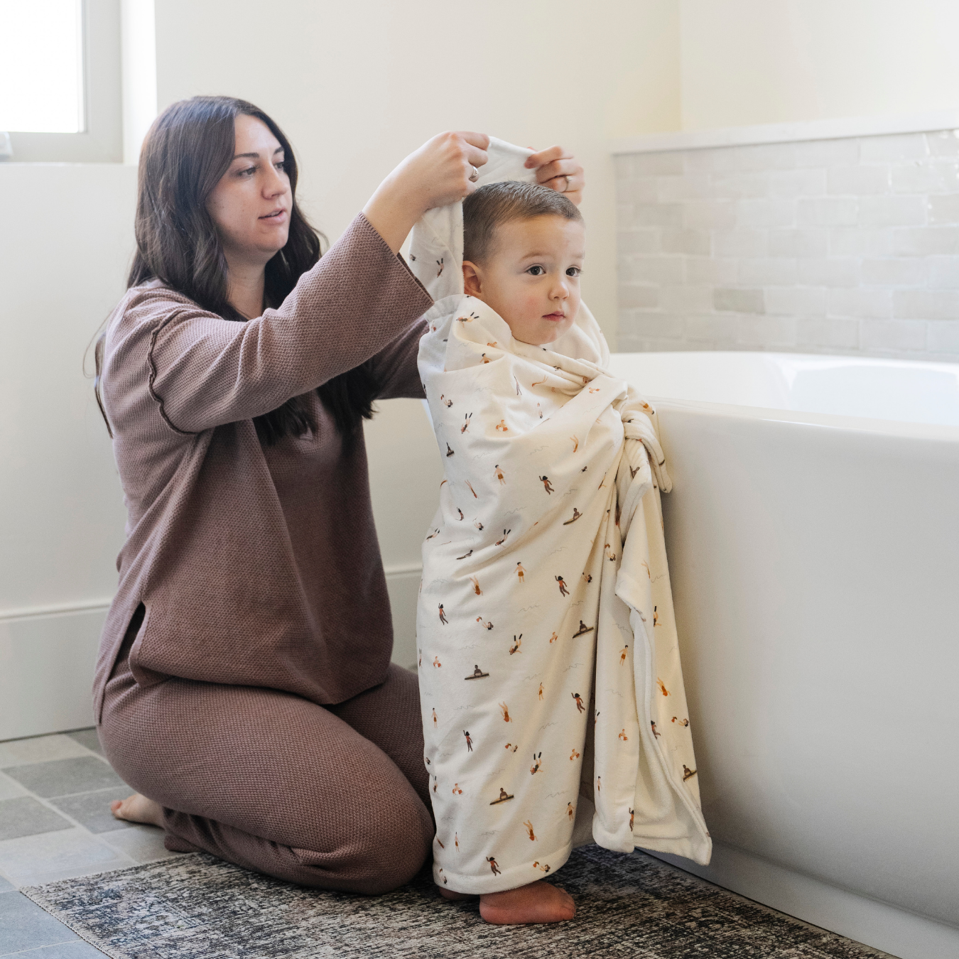 A mother wraps her toddler in a Saranoni hooded towel, made with ultra-soft minky and terrycloth fabric for maximum absorbency and comfort. This luxury hooded towel is perfect for bath time, pool days, and beach outings, offering quick-drying warmth while being gentle on sensitive skin. Designed as a toddler hooded towel, it provides a cozy, plush feel that keeps little ones warm after water play. Ideal for parents looking for the best soft baby towel that combines style, durability, and ultimate comfort.
