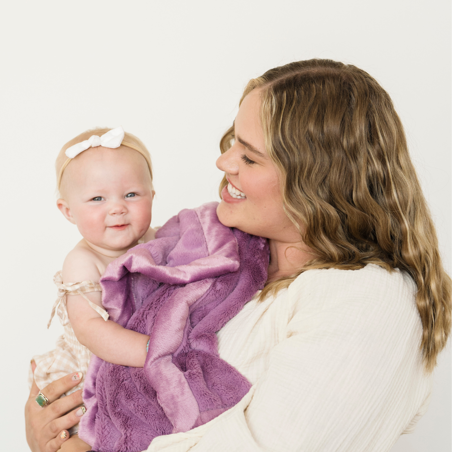 Mom holding baby girl with Fairy Wings Lush Receiving soft baby blanket. 