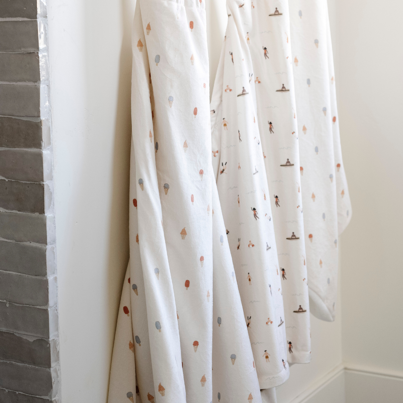 Three Saranoni hooded towels. These luxury hooded towels are perfect for bath time, pool days, and beach outings, being gentle on sensitive skin. Designed as toddler hooded towels, these bath towels provides a cozy, plush feel that keep little ones warm after water play. Ideal for parents looking for the best soft toddler towel that combines style, durability, and ultimate comfort. These kid's towels have an ice cream print or a print with people. These are hooded towels for toddlers. 