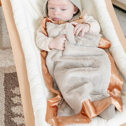 Warm and inviting mini blanket with a satin border, offering a soft, cozy feel with a smooth, polished edge.