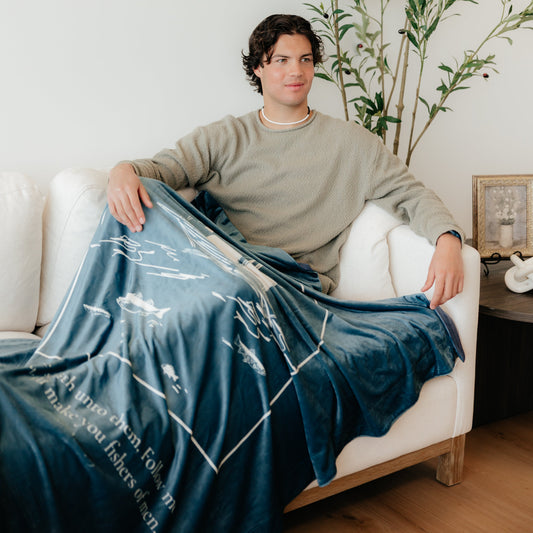 Man wrapped in Fishers of Men Christian blanket featuring Matthew 4:19 scripture – inspirational Christian gift and faith-based throw blanket