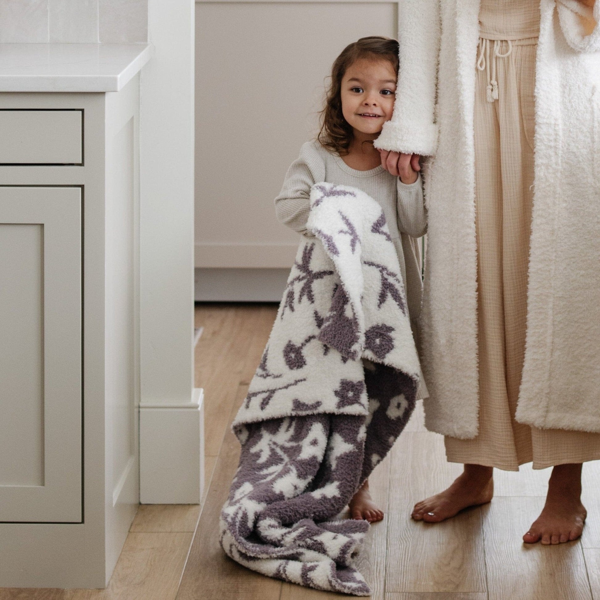 Mom and little girl in the kitchen, holding on to Purple Pansy DOUBLE-LAYER BAMBONI TODDLER BLANKETS - Saranoni