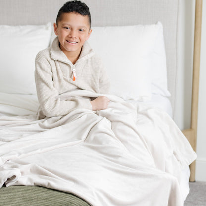Boy snuggling in bed with MINKY STRETCH RECEIVING BLANKETS - Saranoni