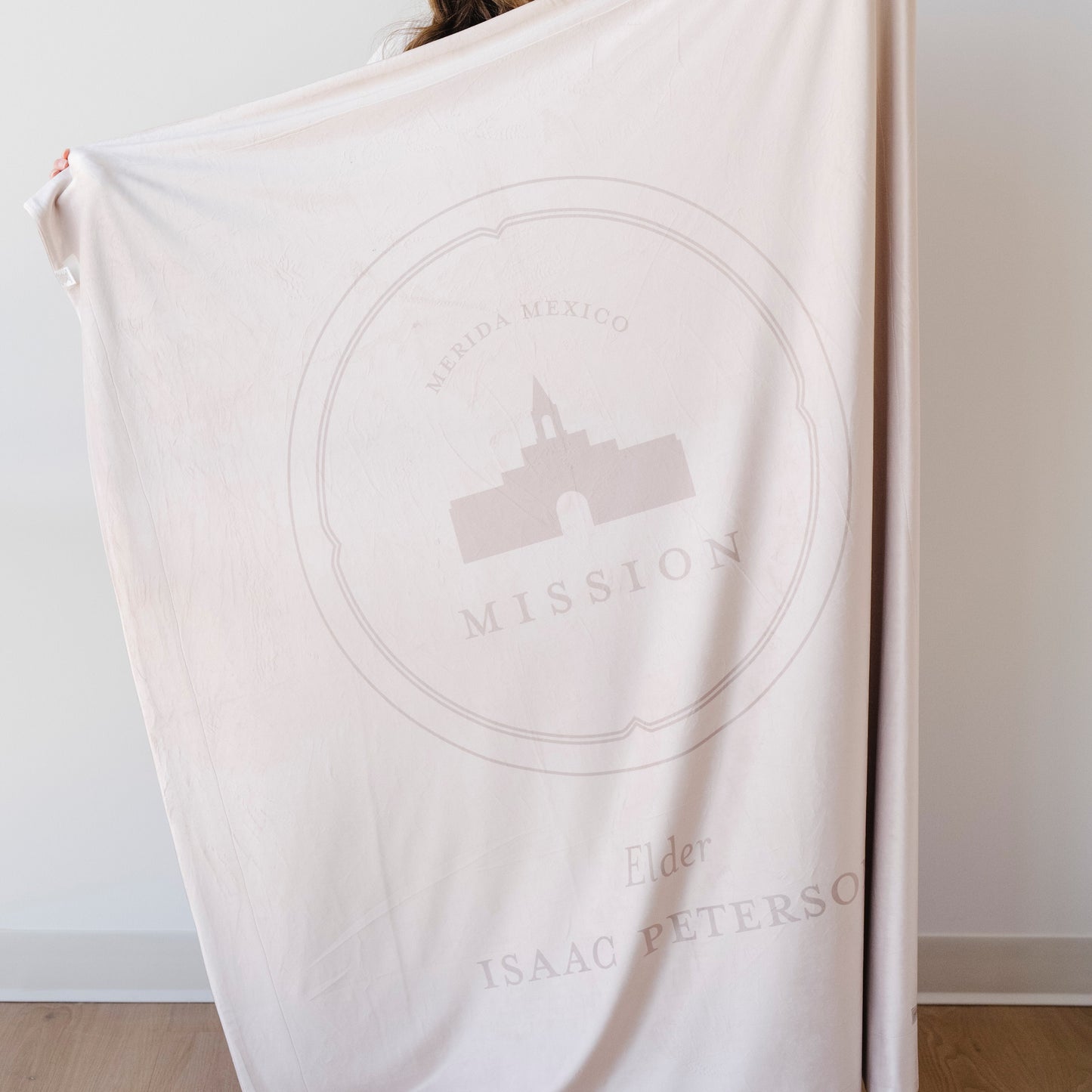 Person holding a personalized missionary blanket featuring the Merida Mexico Mission design, missionary name, and custom mission dates.